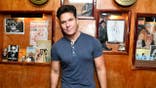 Dane Cook poses in blue shirt