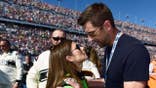 Danica Patrick and Aaron Rodgers stand together on the grid at Daytona International Speedway.