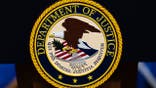 U.S. Department of Justice logo displayed on a podium.
