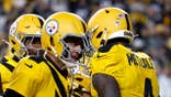 DK Metcalf celebrates a touchdown catch with Aaron Rodgers during a Steelers-Packers game.