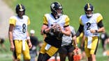 Drew Allar looks to pass during Steelers practice as Aaron Rodgers and Mason Rudolph watch.