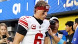 Jaxson Dart walks off the field with an injury during an NFL game between the Giants and Rams.