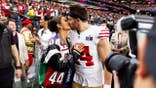 Kyle Juszczyk kisses his wife, Kristin Juszczyk, during pregame warmups.