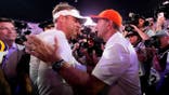 Lane Kiffin and Dabo Swinney greet each other after a college football game.