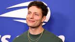 Matt Rife stands on the blue carpet at the USTA Billie Jean King National Tennis Center.