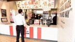 A man orders from the register at a KFC restaurant.