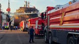Firefighters and crews gather near the cargo ship