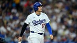 Shohei Ohtani walks to first base after being hit by a pitch.