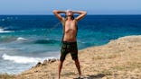 Stephen Lashbrook looking triumphant in front of ocean.