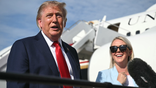 President Donald Trump speaks to reporters alongside Karoline Leavitt.