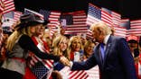 Donald Trump greets attendees while walking on stage at the American Airlines Center in Dallas, Texas.