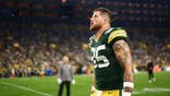 Tucker Kraft walks on the field before a game at Lambeau Field.