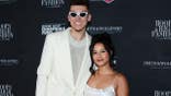 Tyler Herro and Katya Elise Henry pose on a red carpet.