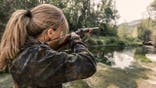 Woman bird hunter stands outdoors.