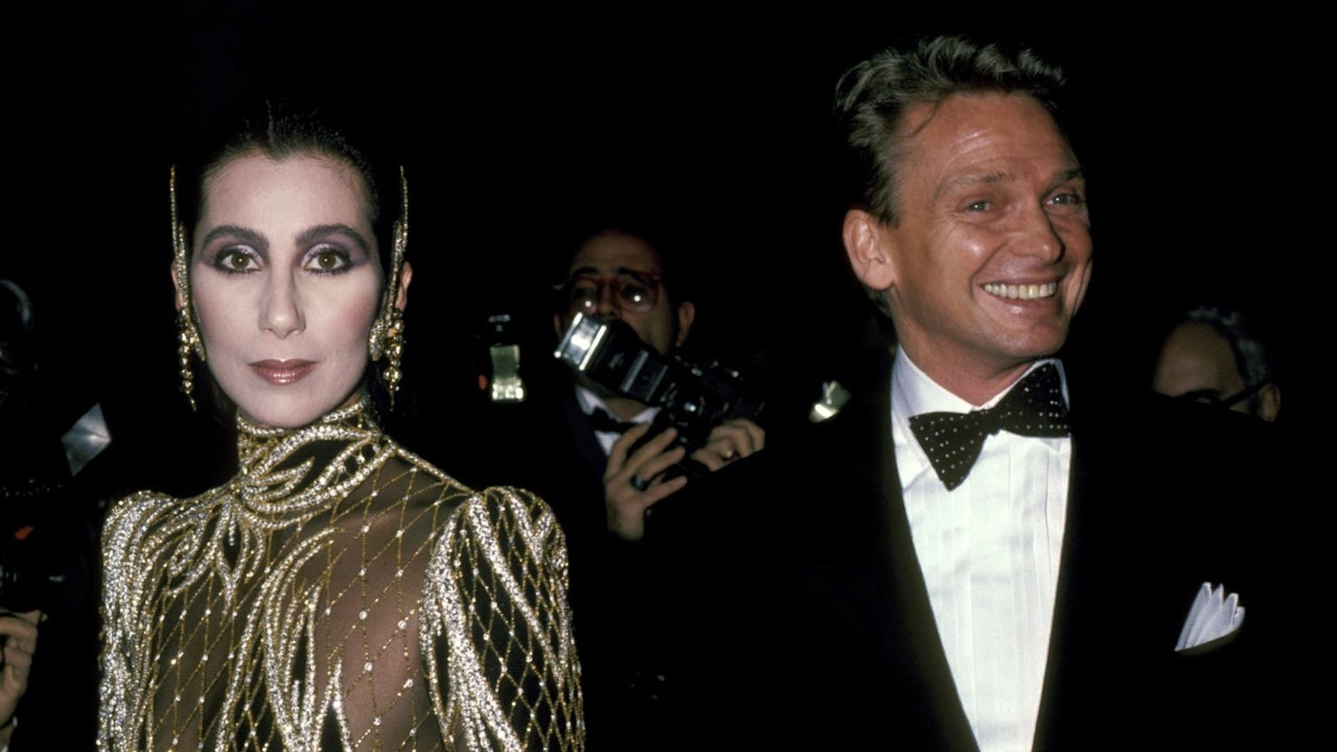 Cher and Bob Mackie stand together at Diana Vreeland's Costume Exhibit.