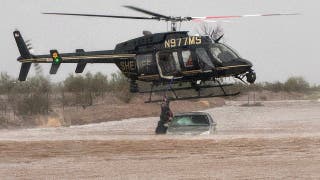 Un sheriff de Arizona utiliza un helicóptero para rescatar a dos personas atrapadas en un coche inundado