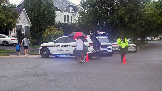 Loudoun County Sheriff's Office vehicles and deputies at the scene of a fatal shooting in Aldie, Virginia.