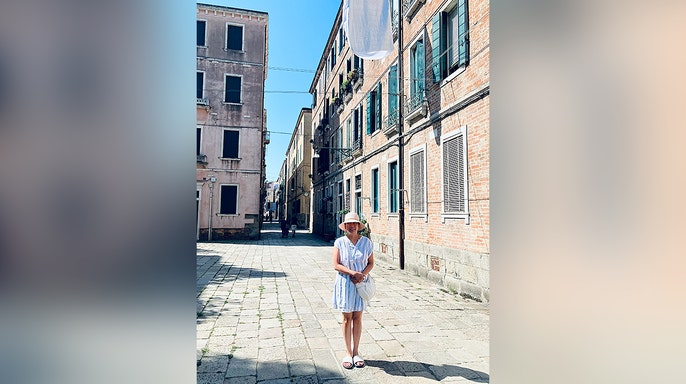 Woman stands on cobblestone street
