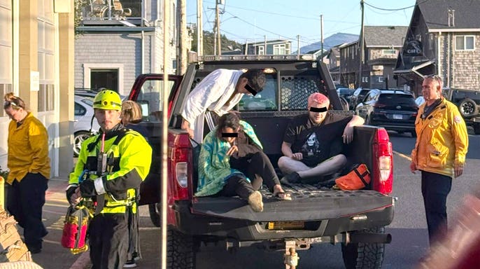 three rescued thrill-seekers in the back of a fire department pickup truck