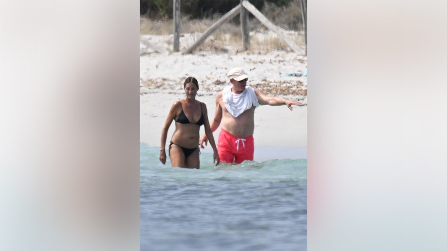 Yasmin and Simon Le Bon in knee-deep water while swimming in Sardinia.