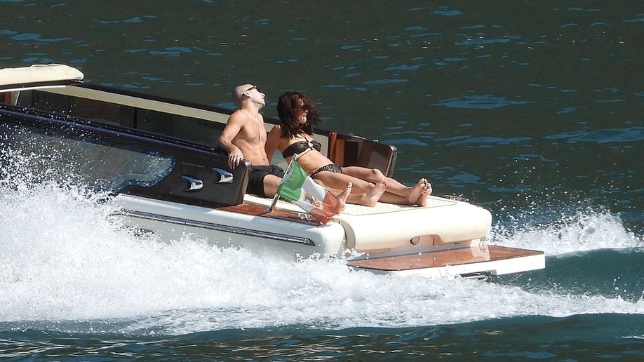 Holmes and Yarmosky speeding away on a boat on Lake Como.