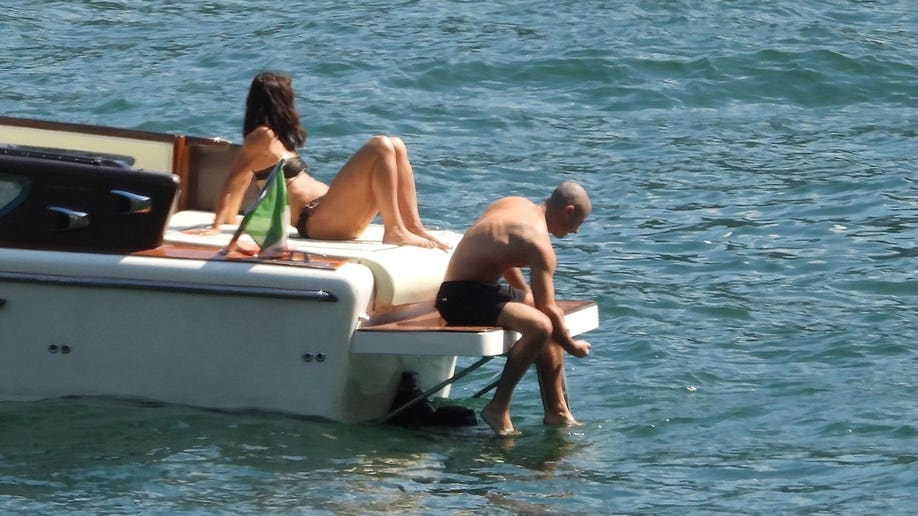 Katie Holmes and Jason sitting on the edge of the boat.