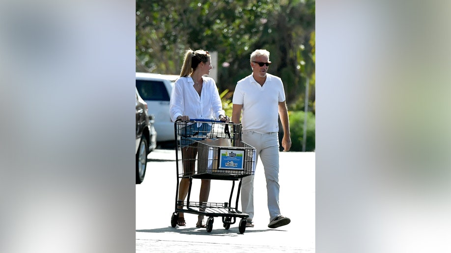 Costner and the lifestyle coach walked side by side through the parking lot and in the aisles.