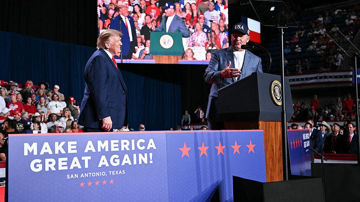 Donald Trump listens as Roger Clemens speaks at a campaign rally at Freeman Coliseum.