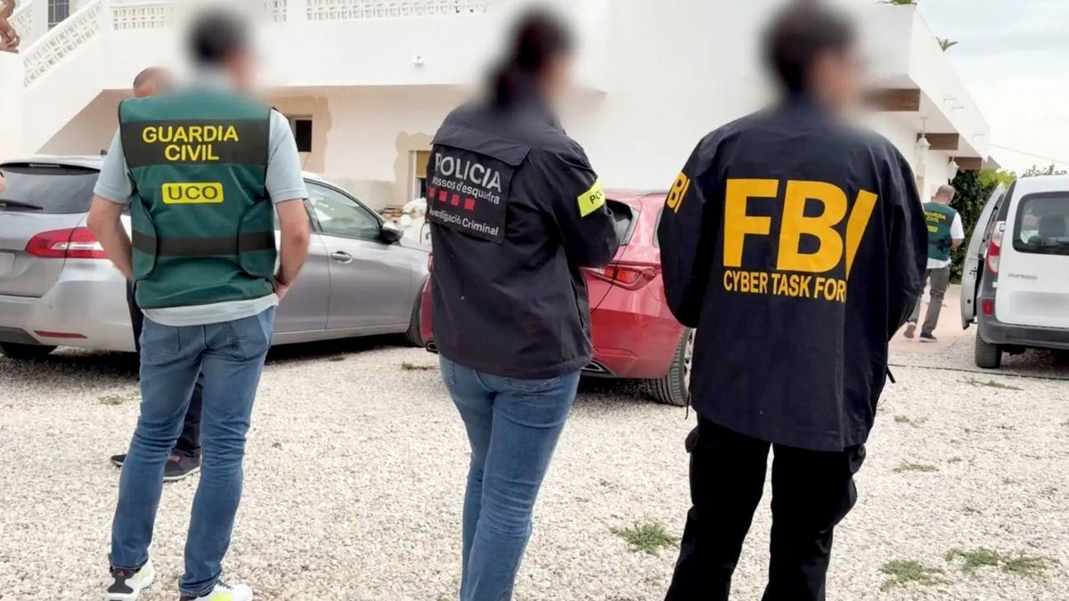 Agents from the FBI, Guardia Civil and Mossos d’Esquadra stand together.