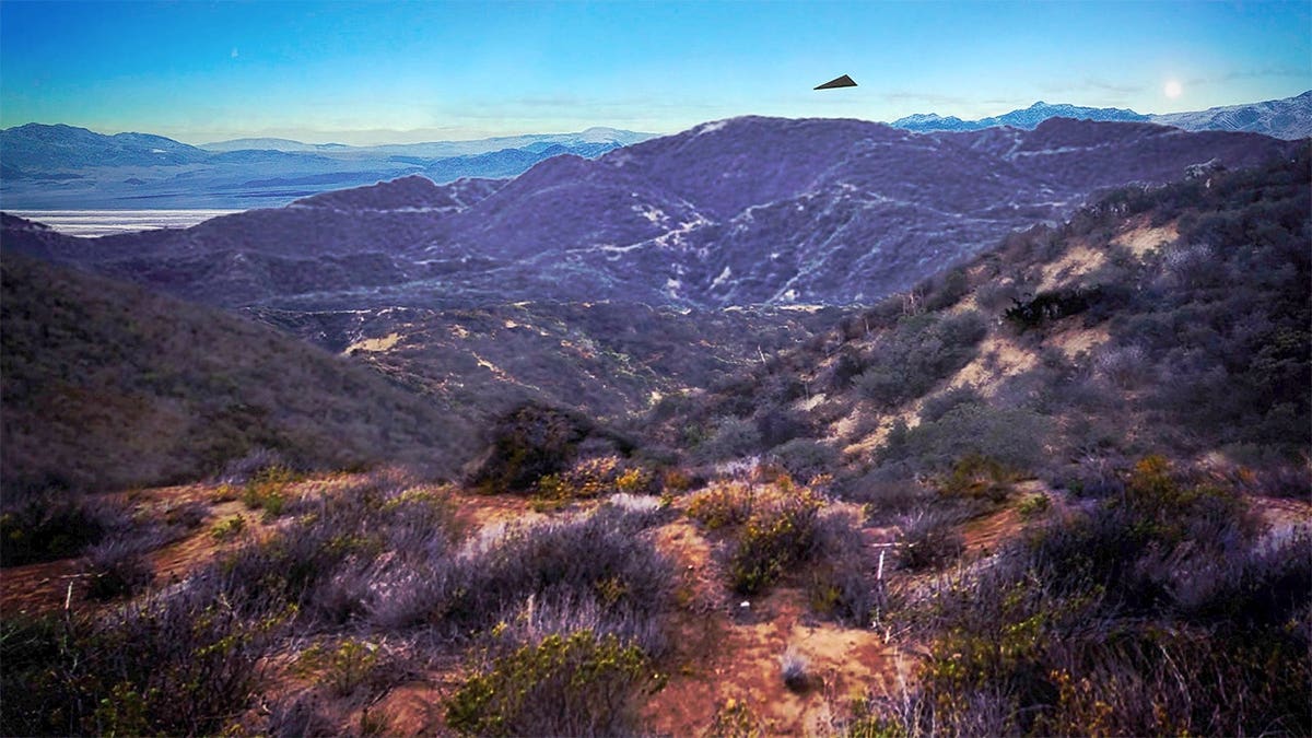 Black triangular shape appears above a mountain ridge in an image included with a federal report documenting a 2026 unidentified aerial object sighting.
