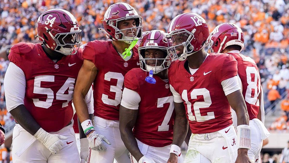 Alabama football players celebrating a touchdown at Neyland Stadium