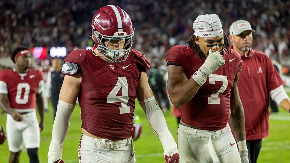 Luke Metz and Caleb Woodson walk off the field after Alabama's loss to Georgia.