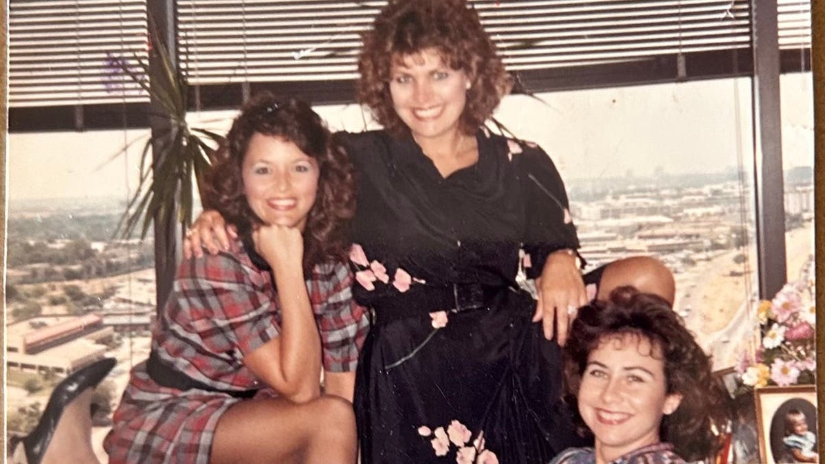 Beverly Lambert, Cathy Mahone and another woman posing together and smiling in the 1980s.