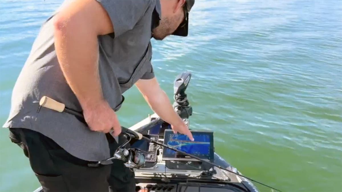 pro angler Cooper Gallant points to forward-facing sonar screen on bass boat