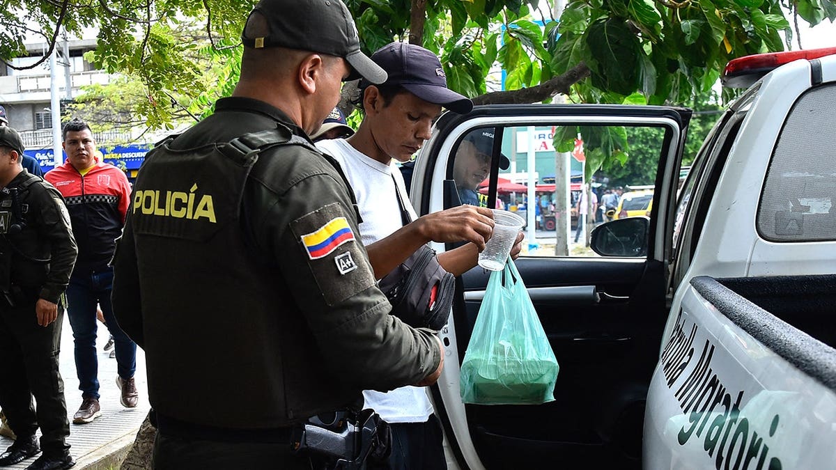 Image of police detaining man in North Santander