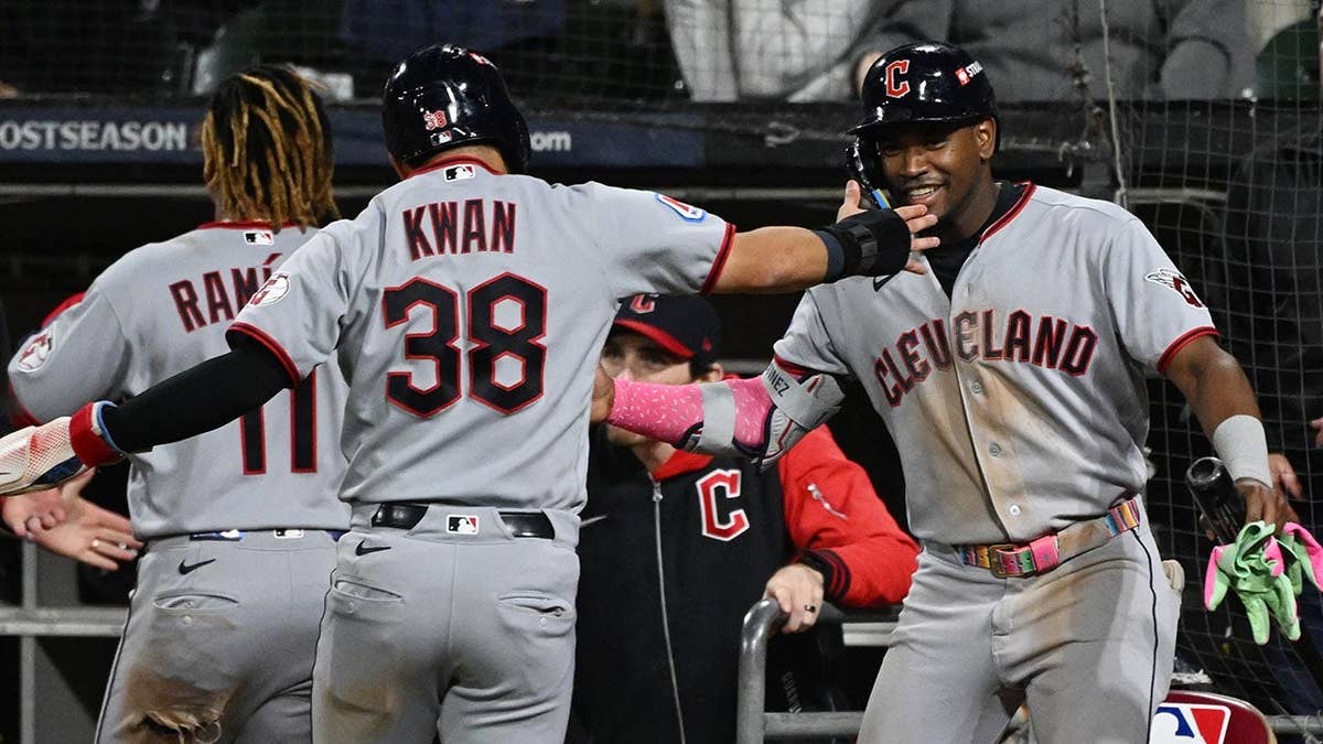 Angel Martinez and Steven Kwan celebrate after Kwan scores during an ALDS playoff game.