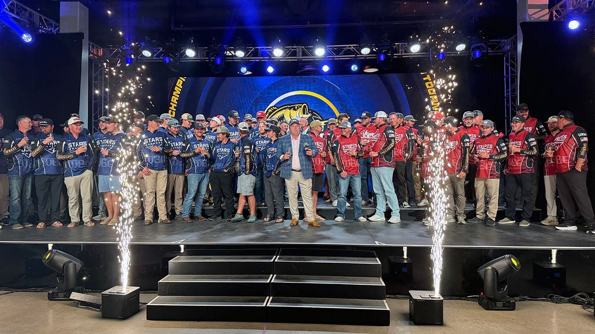 anglers line up on stage holding champagne