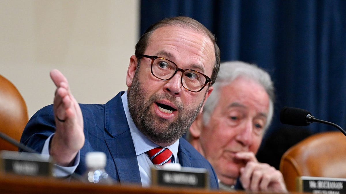 Rep. Jason Smith, R-Mo., gestures while speaking at a House Ways and Means Committee hearing, with Rep. Richard Neal, D-Mass., seated behind him.