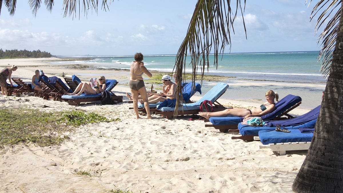 View of tourists near the Indian Ocean on a Kenyan beach