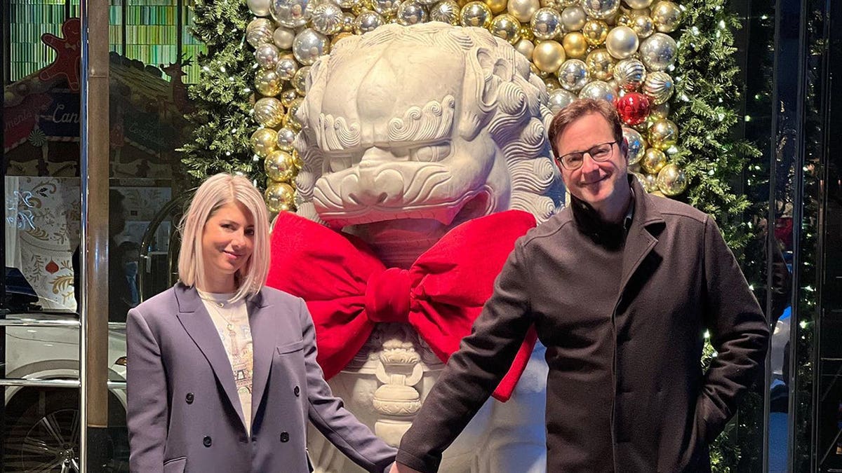 Kelly Rizzo and Bob Saget holding hands on Christmas.