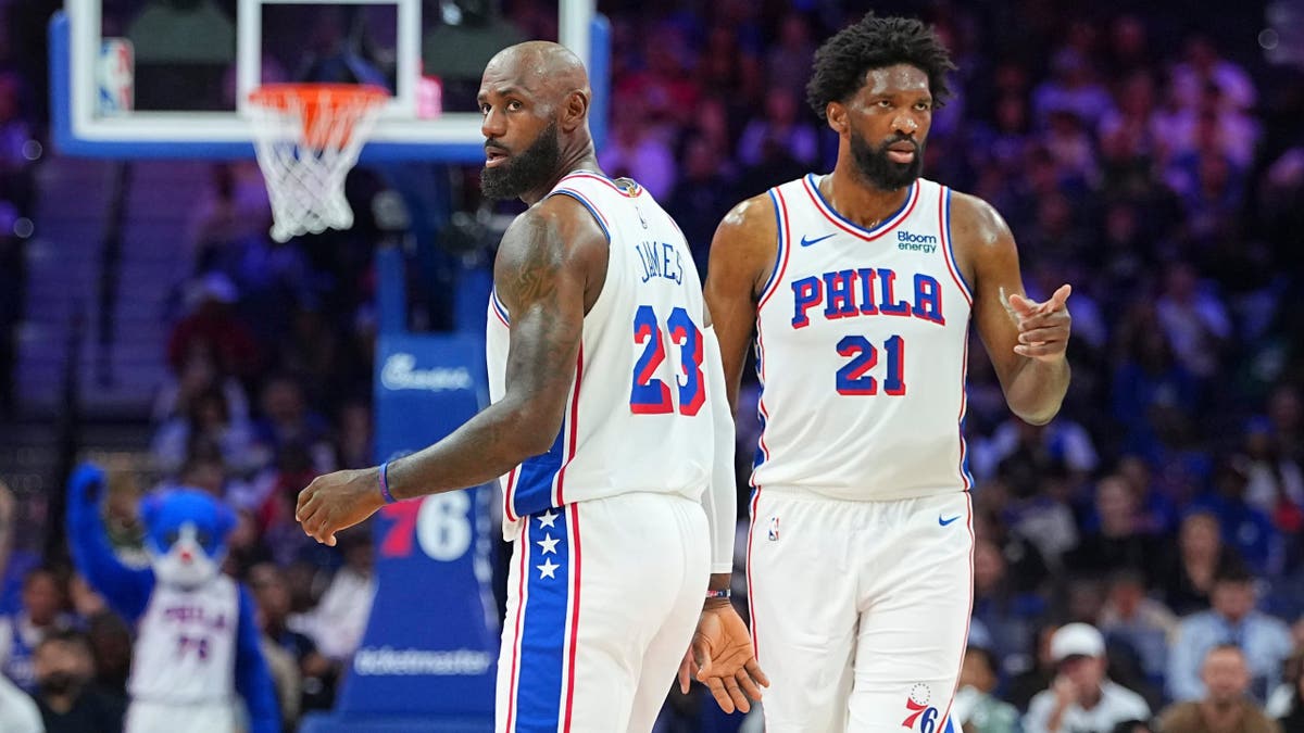 LeBron James and Joel Embiid looking on during a preseason game
