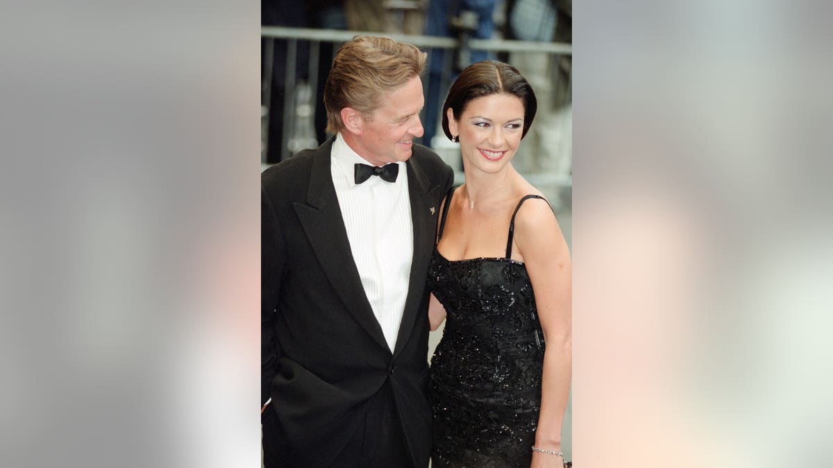 Catherine Zeta-Jones and Michael Douglas stand together at the Entrapment film premiere.