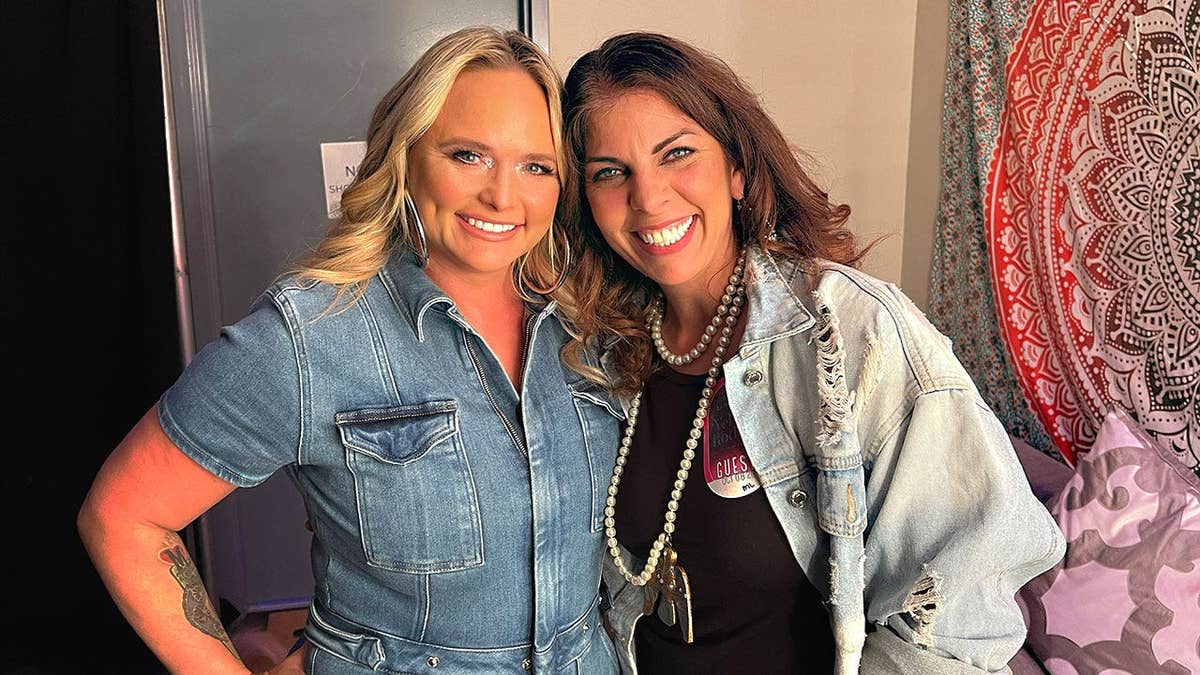 Miranda Lambert and Lauren Burns smiling backstage.