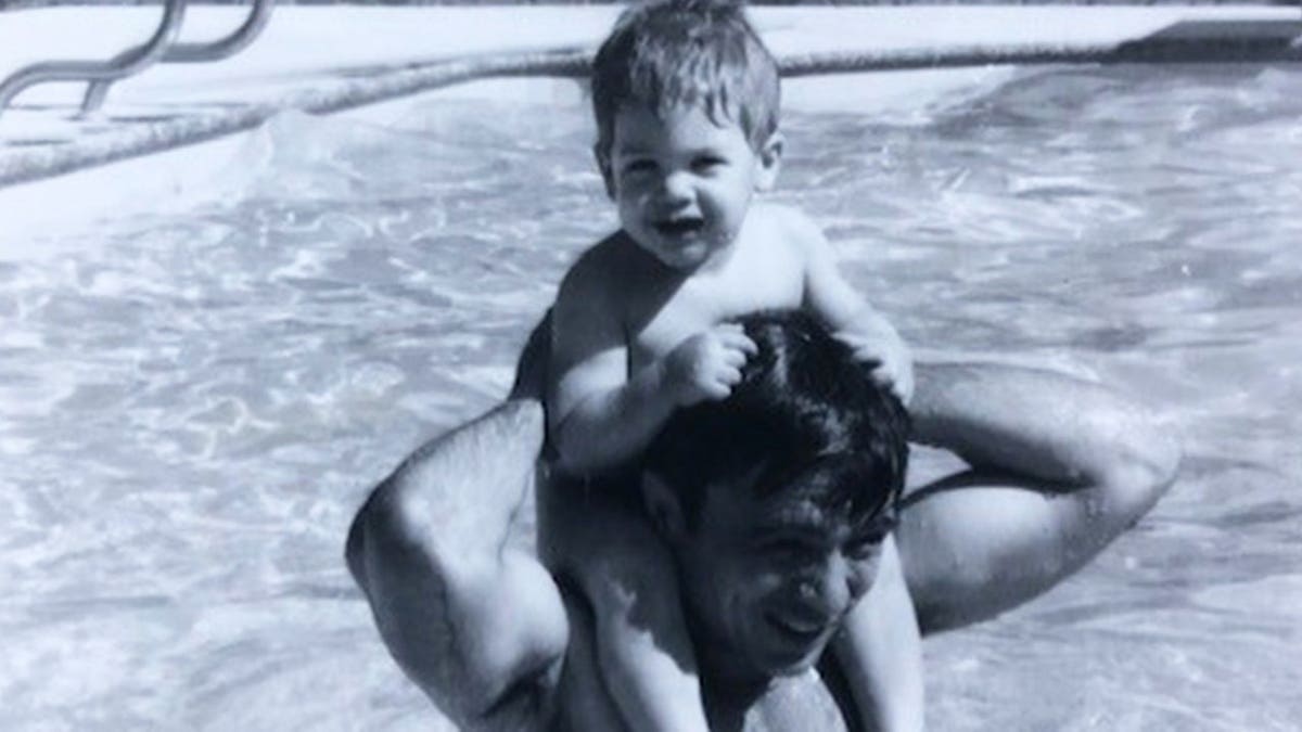 A black and white photo of baby Noah Blake in a pool with his father Robert Blake.