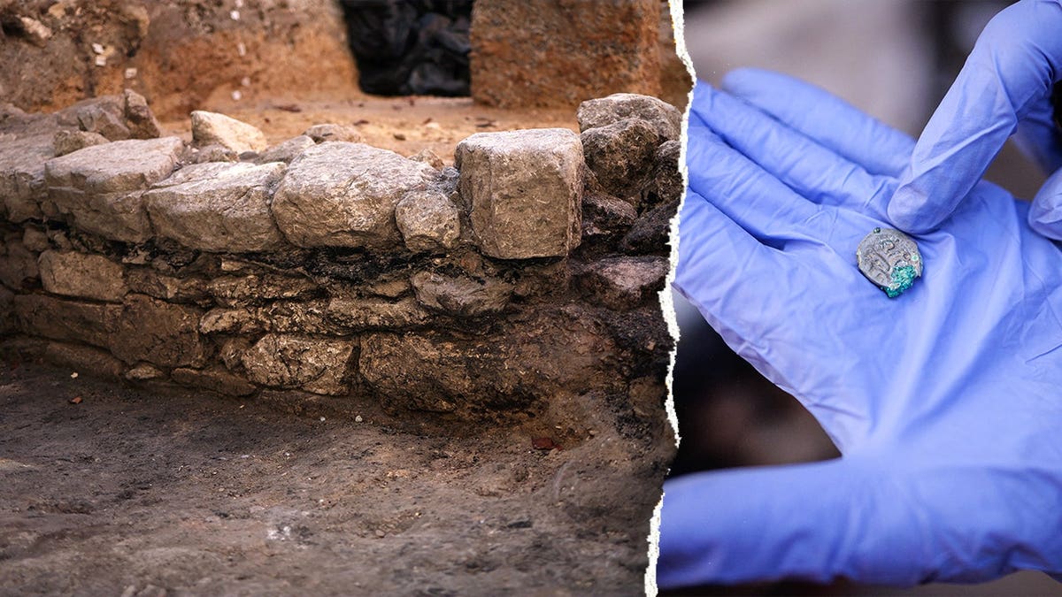 View of ancient wall, hand holding ancient coin found