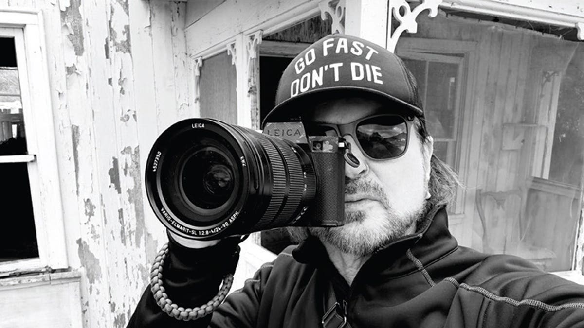 Rikki Rockett holding a camera.