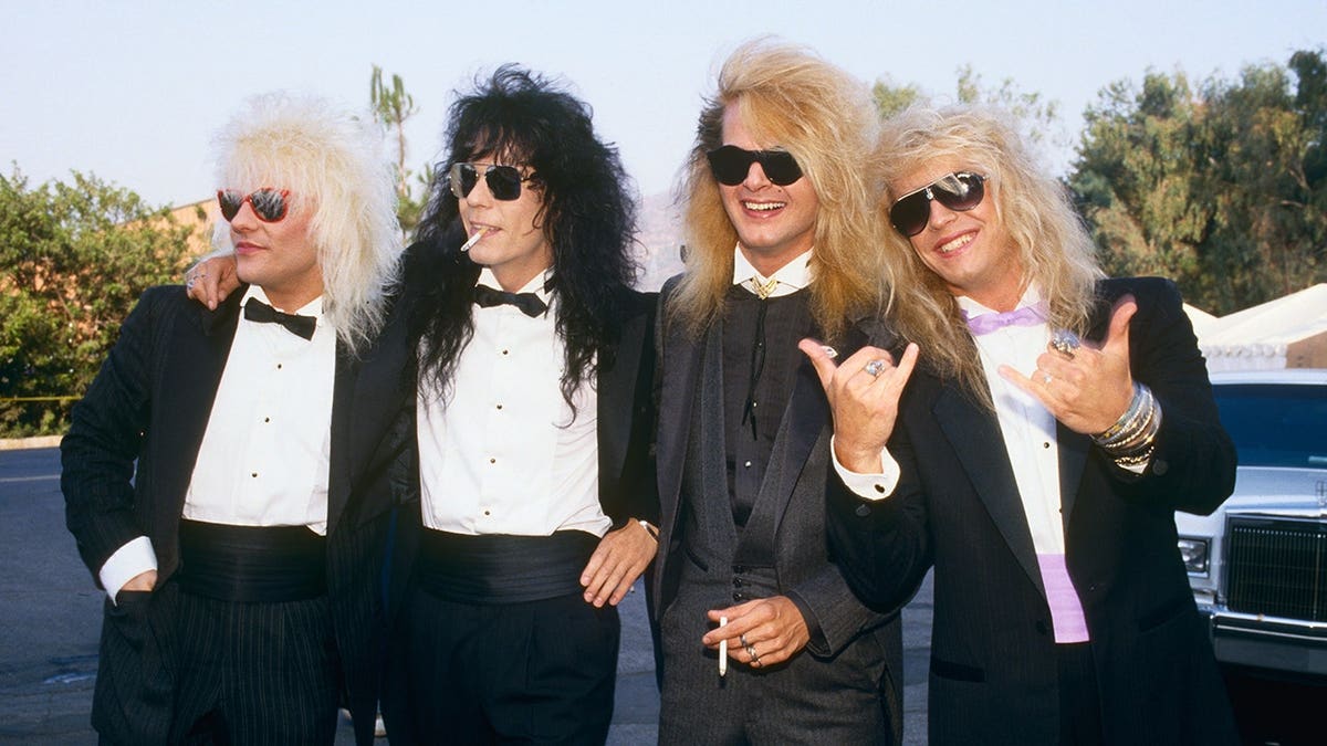 Rikki Rockett, Bret Michaels, C.C. DeVille and Bobby Dall of Poison pose on the red carpet.