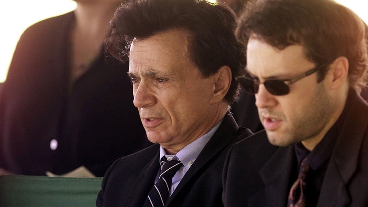 Robert Blake and his son Noah Blake stand in front of a coffin during a funeral ceremony in Los Angeles.