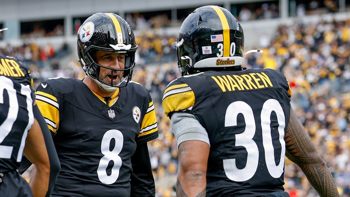 Aaron Rodgers and Jaylen Warren of the Pittsburgh Steelers celebrate during the third quarter.