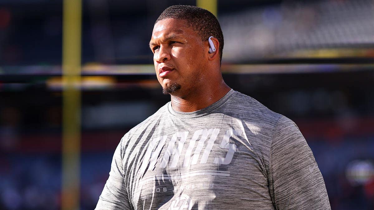Alaric Jackson warms up on the field before a game in Denver.